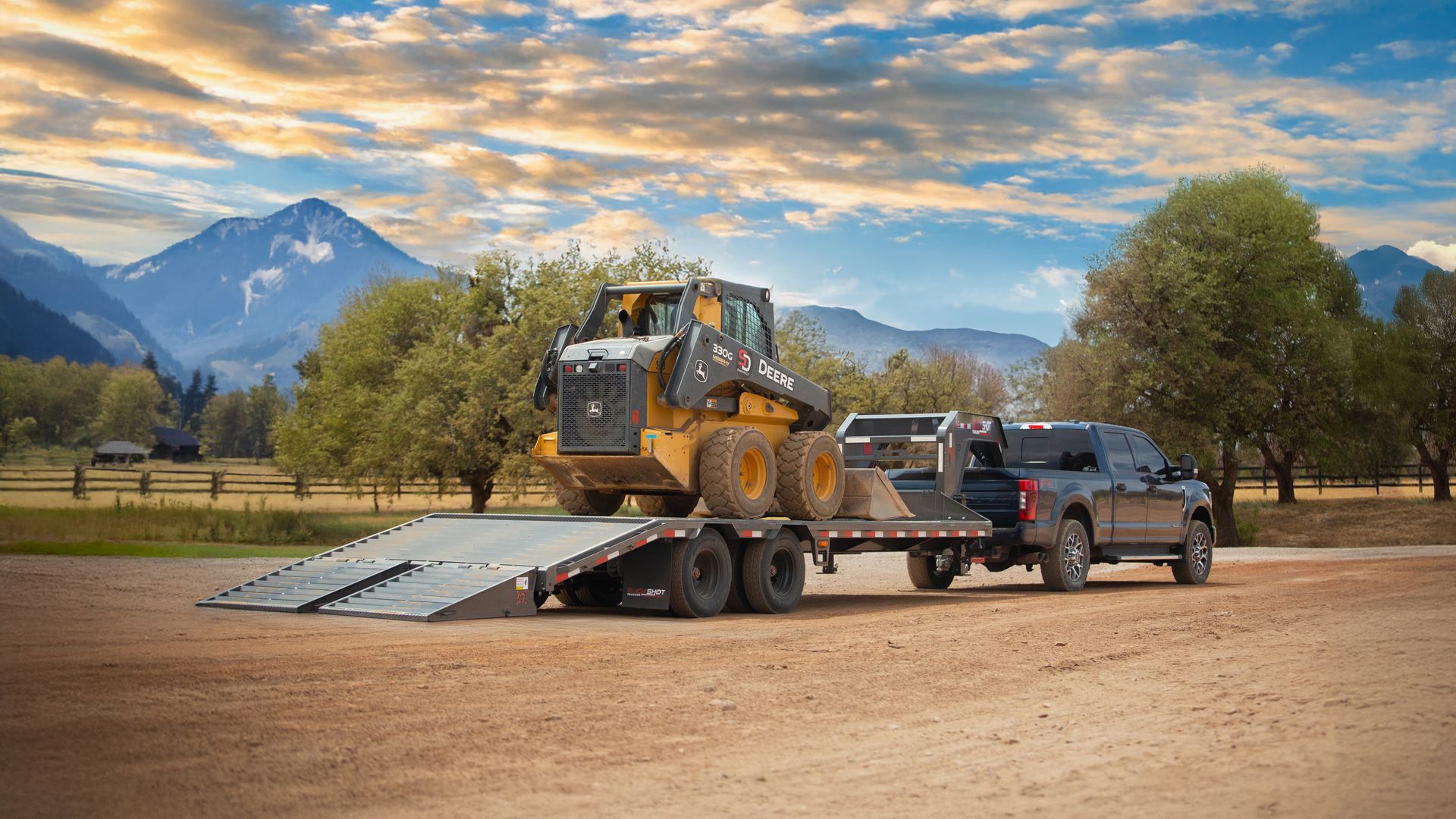 Buckshot gooseneck deckover trailer loaded with a skid steer